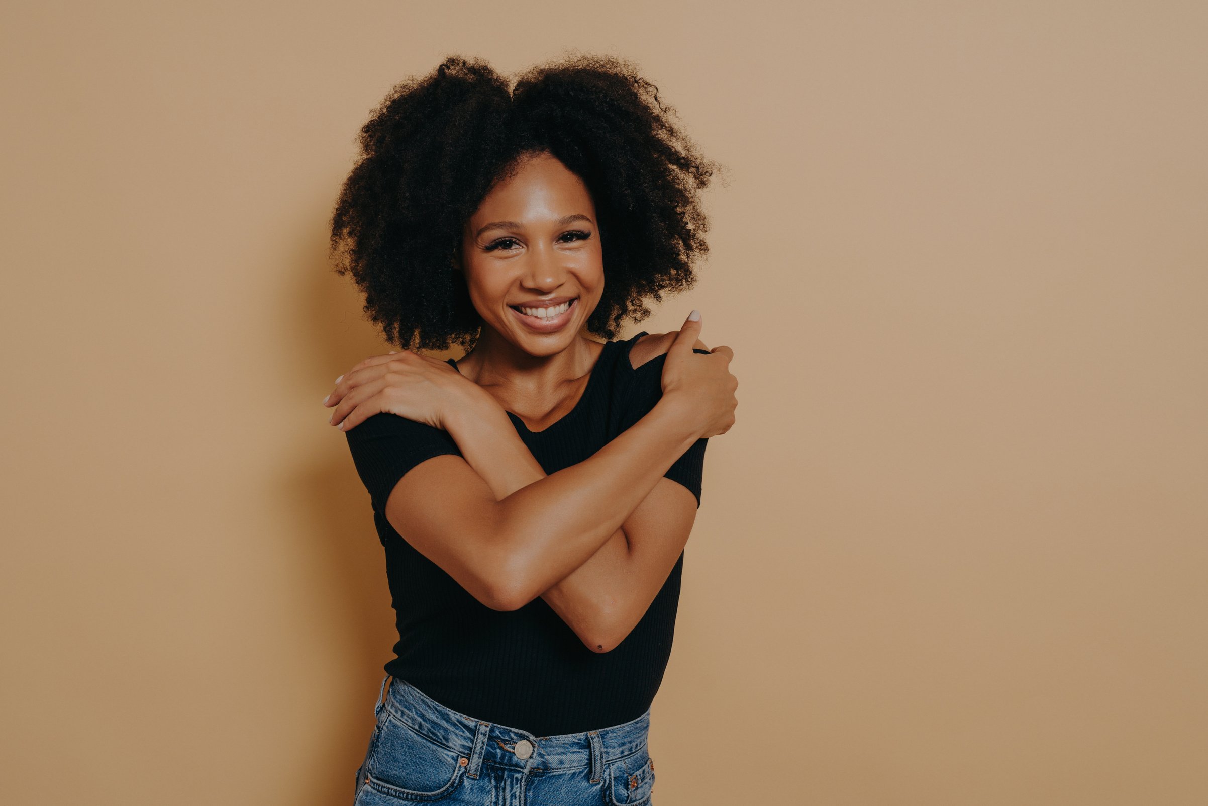 Image of beautiful pleased young dark skinned female with vo